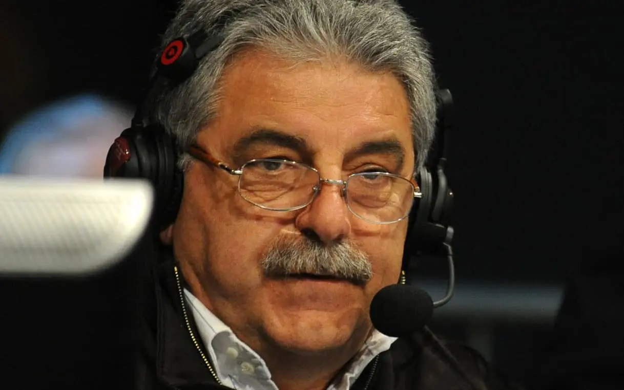 Close-up portrait of Franco Ligas wearing glasses and a headset with a microphone