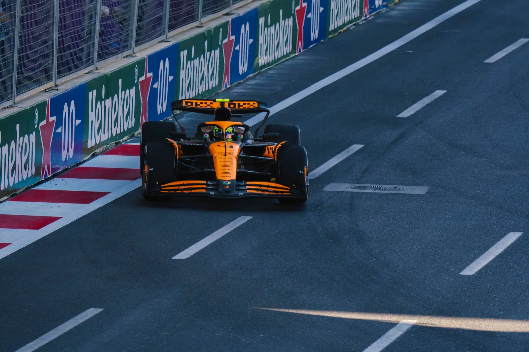 Lando Norris driving the orange and black McLaren Formula 1 car on a race track